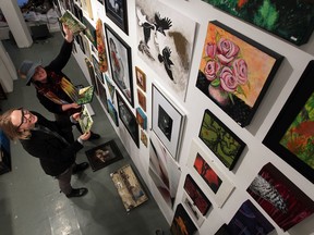 In this photo from Nov. 26, Artcite installers Sasha Opeiko, left, and Judy Chappus make room for some of their artwork for Doin' The Louvre, the 33rd annual show and sale. (NICK BRANCACCIO / The Windsor Star)