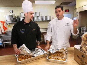Chef Roger Poirier, left, regularly picks up leftover food from banquet halls to redistribute to community organizations. He's shown at the Caboto Club with chef Steve Ward picking up a couple trays of pasta. (DAN JANISSE / The Windsor Star)