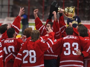 Members of the Brennan Cardinals boys hockey team hoist the Zakoor Cup after defeating the St. Joseph's Lasers 4-2 in the Father Zakoor Catholic Cup at the WFCU Centre, Friday, Dec. 19, 2014.   (DAX MELMER/The Windsor Star)