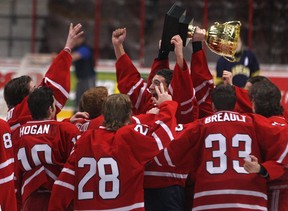 Members of the Brennan Cardinals boys hockey team hoist the Zakoor Cup after defeating the St. Joseph's Lasers 4-2 in the Father Zakoor Catholic Cup at the WFCU Centre, Friday, Dec. 19, 2014.   (DAX MELMER/The Windsor Star)