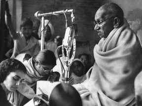 In a Jan. 22, 1948 file photo, Mohandas K. Gandhi squats before a microphone in New Delhi, India, to deliver prayer meeting discourse during second day of his fast to force communal peace in India. New England Brewing Co. in Connecticut is apologizing to Indians offended that the company is using Mohandas Gandhi's name and likeness on one of its beers. The brewery apologized on its Facebook page for the India pale ale it calls Gandhi-Bot. Critics in the U.S. and India have complained about the commercial use of Gandhi, revered for leading India to independence through nonviolence. (AP Photo/File)