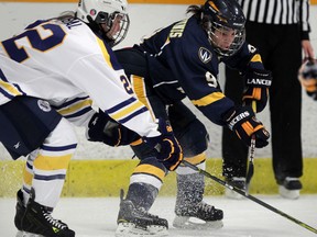 University of Windsor's Candace Kourounis, right, passes in front of Laurentian's Sara Habal during OUA women's hockey action at South Windsor Arena, January 9, 2015. (NICK BRANCACCIO/The Windsor Star)