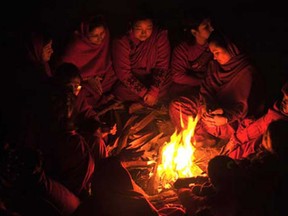 Nepalese Hindu devotees warm themselves beside a fire after bathing in the Shali River on the outskirts of Kathmandu on January 5, 2015, on the first day of month-long Swasthani festival. Hundreds of married and unmarried women in the Himalayan nation have started a month-long fast in the hope of a prosperous life and conjugal happiness.
