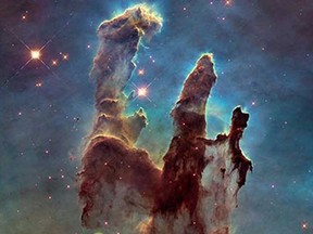 A handout photo released on January 6, 2015 by the NASA/ESA Hubble Space Telescope shows one of its most iconic and popular images revisited : the Eagle Nebulas Pillars of Creation. This image shows the pillars as seen in visible light, capturing the multi-coloured glow of gas clouds, wispy tendrils of dark cosmic dust, and the rust-coloured elephants trunks of the nebulas famous pillars. The dust and gas in the pillars is seared by the intense radiation from young stars and eroded by strong winds from massive nearby stars. With these new images comes better contrast and a clearer view for astronomers to study how the structure of the pillars is changing over time.
