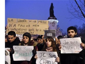A man holds a placard reading : "Freedom of the press is priceless, fundamentalism, of any kind, will not pass" as others hold up placards reading in French, "I am Charlie" during a gathering at the Place de la Republique (Republic square) in Paris, on January 7, 2015, following an attack by unknown gunmen on the offices of the satirical weekly, Charlie Hebdo. France's Muslim leadership sharply condemned the shooting at the Paris satirical weekly that left at least 12 people dead as a "barbaric" attack and an assault on press freedom and democracy.
Photograph by: DOMINIQUE FAGET , Ottawa Citizen
