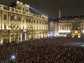 Thousands of people gather for a moment of silence to pay their respects to the victims of the deadly attack at the Paris offices of French satirical newspaper Charlie Hebdo, in Lyon, central France, Wednesday, Jan. 7, 2015. Masked gunmen stormed the Paris offices of a weekly newspaper that caricatured the Prophet Muhammad, killing at least 12 people, including the editor, before escaping in a car. It was France's deadliest postwar terrorist attack.
