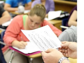 A Social studies teacher reviews an assignment at an Alberta school on June 10, 2012. (Lorraine Hjalte/Postmedia News)