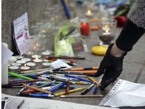 A woman places a pen in the central square of the French eastern city of Strasbourg on Jan. 8, 2015, to pay tribute to the victims of an attack by armed gunmen on the offices of French satirical newspaper Charlie Hebdo in Paris on Jan. 7 which left at least 12 dead and many others injured.
Photograph by: PATRICK HERTZOG/AFP/Getty Images)