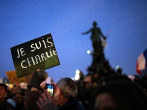 A demonstrator holds a sign reading "I am Charlie" at Place de la Nation during a rally in Paris, Sunday, Jan. 11, 2015. Hundreds of thousands gathered Sunday throughout Paris and cities around the world, to show unity and defiance in the face of terrorism that killed 17 people in France's bleakest moment in half a century.