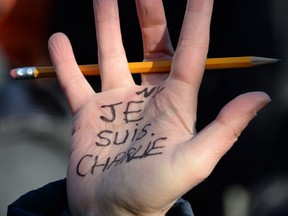A man with Je Suis Charlie written on his hand holds a pencil during a memorial at Washington Square Park on January 10, 2015, in New York. About 500 mourners gathered at the park to remember the victims of the Paris attacks. AFP PHOTO/DON EMMERTDON EMMERT/AFP/Getty Images