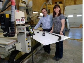 Owners Mark and Carolyn Perry of Plas-Tech Fabrications stand with one of their sporting goods products, a Pro Shot Ice Simulator, at their shop in Ottawa on Friday, January 16, 2015. Their operation pumps out specialized plastic products - everything from patented storm-drain basins to giant toy guns for water parks. THE CANADIAN PRESS/Sean Kilpatrick