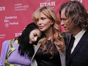 Frances Bean Cobain, left, daughter of Kurt Cobain and executive producer of the documentary film "Kurt Cobain: Montage of Heck," is embraced by her mother and Cobain's widow Courtney Love as the film's director/writer/producer Brett Morgen looks on at the premiere of the film at The MARC Theatre during the 2015 Sundance Film Festival on Saturday, Jan. 24, 2015, in Park City, Utah. (Photo by Chris Pizzello/Invision/AP)