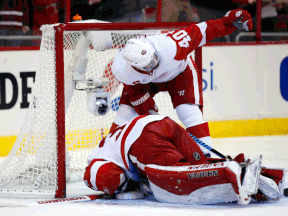 Detroit's Henrik Zetterberg, top, calls for help after goalie Jimmy Howard was injured in the first period against the Washington Capitals Saturday, (AP Photo/Alex Brandon)
