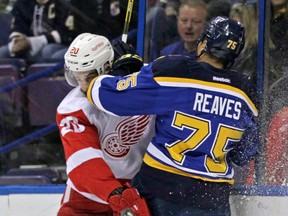 Detroit's Drew Miller, left, collides with St. Louis' Ryan Reaves in the first period Thursday in St. Louis. (AP Photo/Tom Gannam)