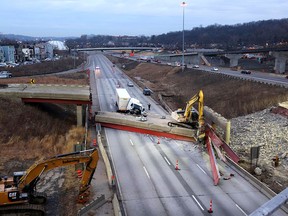 An early morning look of the aftermath of the bridge collapse on Interstate 75, Tuesday, Jan. 20, 2015 in Cincinnati, Ohio. The collapse killed a worker and injured a truck driver. The Ohio Department of Transportation said the busy artery through downtown Cincinnati will be closed at least two to three days. (AP Photo/The Enquirer, Liz Dufour)