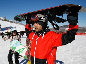 Actor and producer Adrian Grenier, right, carries his snowboard on his head as he makes his way to the lift at Park City Mountain Resort during the 2015 Sundance Film Festival on Monday, Jan. 26, 2015, in Park City, Utah. While celebrities are consistently swarmed by fans at the Sundance Film Festival, there's one place they can find anonymity: On the slopes, which are empty as most out-of-towners are holed up in screenings. (Photo by Danny Moloshok/Invision/AP)