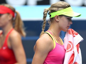 Canada's Eugenie Bouchard, right, wipes her face as Maria Sharapova looks on in her quarter-final match at the Australian Open. (Photo by Hannah Peters/Getty Images)
