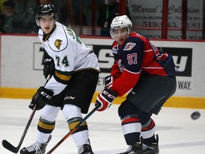 London's Aiden Jamieson, left, flips a pass in front of Windsor's Anthony Stefano in OHL action at the WFCU Centre Thursday. (NICK BRANCACCIO/The Windsor Star)