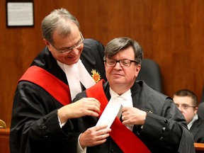 Mr. Justice Duncan Grace, left, assists George W. King with Superior Court Judges judicial robes and sash and Mr. Justice King addressed the court where many friends, family, legal associates, sitting Justices and community leaders attended the event on Friday, Jan. 30, 2015. Former Premier The Honourable Ernie Eves, Q.C. was King's personal speaker. (NICK BRANCACCIO/The Windsor Star)