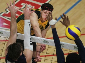 St. Clair's Jason Hernandez, centre, spikes the ball between Humber's Alex Lewicki, left, and Terrel Bramwell during OCAA men's volleyball action at the SportsPlex Saturday. (DAX MELMER/The Windsor Star)
