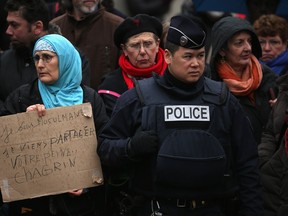PARIS, FRANCE - JANUARY 15:  Amid tight security, a woman holds up a sign saying 'I am a Muslim. I come to share your grief' as members of the public arrive to pay their respects at the funeral of Charlie Hebdo cartoonist Bernard 'Tignous' Verlhac at Père Lachaise Cemetery on January 15, 2015 in Paris, France.  Cartoonist Bernard 'Tignous' Verlhac was killed in last weeks' terrorist attack on satirical newspaper Charlie Hebdo.  (Photo by Christopher Furlong/Getty Images)