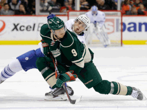 Minnesota's Mikko Koivu, front, is checked by Toronto's Gregg McKegg during the second period Friday in St. Paul, Minn. (AP Photo/Ann Heisenfelt)