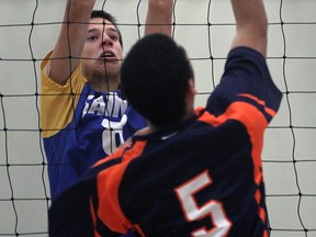 St. Anne's Brad Gyemi, left, goes up for a block against Sandwich's Brandon Lee-Hyman during a game in Lakeshore. (DAN JANISSE/The Windsor Star)