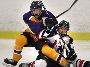 Holy Names' Alex Mosher, right, gets tangled up with Kingsville's Auston Wilds  during high school hockey action at South Windsor Arena Tuesday. (JASON KRYK/The Windsor Star)