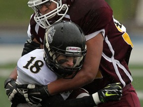 General Amherst's Eric Wismer, left, is wrapped up by Leamington's Mojtaba Mehry at Alumni Field in Windsor. (TYLER BROWNBRIDGE/The Windsor Star)