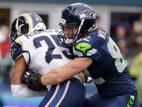 LaSalle's Luke Willson, right, tackles St. Louis Rams strong safety T.J. McDonald after McDonald recovered a fumble by Marshawn Lynch Dec. 28 in Seattle. (AP Photo/Elaine Thompson)
