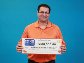 Anthony Lahoud of Windsor holds the $100,000 cheque he collected at the OLG's prize centre in Toronto on Jan. 10, 2015. (Handout / The Windsor Star)