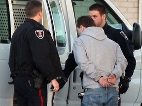 A U.S. man who crossed the border in a stolen truck is put into a prisoner transport by Windsor police officers on Jan. 7, 2015. (Nick Brancaccio / The Windsor Star)