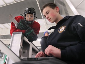 Corpus Christi student Joel Badour inputs performance data from Andrew Kopcok at the F.J. Brennan Centre of Excellence and Innovation Hockey Canada Skills Academy on Tuesday, Jan. 27, 2015, in Windsor, ON. (DAN JANISSE/The Windsor Star)