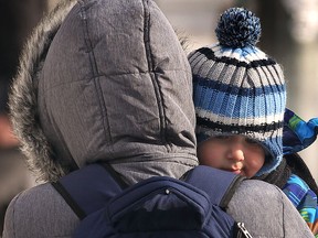 A bundled up woman and child brave the cold and wind in downtown Windsor on Monday, Jan. 5, 2015. (DAN JANISSE/The Windsor Star)