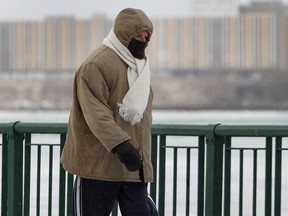 A bundled up walker battles the cold and wind along the downtown Windsor, ON. waterfront on Monday, Jan. 5, 2015. (DAN JANISSE/The Windsor Star)
