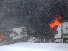Vehicles burn at the scene of a fiery crash that closed both sides of Interstate 94, Friday, Jan. 9, 2015, between mile markers 88 and 92 in eastern Kalamazoo County, near Galesburg, Mich. State police say at least one person has died in the series of crashes involving roughly 150 vehicles, including at least two semi-trucks carrying fireworks and other hazardous materials. Authorities are blaming snow, wind and poor visibility in the crash. (AP Photo/Kalamazoo Gazette-MLive Media Group, Mark Bugnaski)
