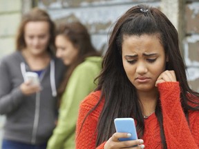 A teen girl is bullied through text messaging. (Fotolia.com)