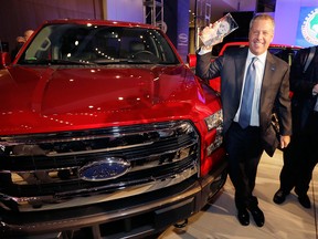 Joe Hinrichs, Ford executive vice president and president, the Americas, poses with the Ford F-150 truck after winning the North American Truck of the Year during the North American International Auto Show, Monday, Jan. 12, 2015, in Detroit. (AP Photo/Carlos Osorio)