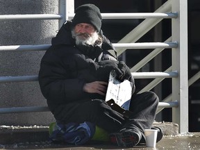 A panhandler known as Gramps panhandles for money on Ouellette Ave. on Tuesday, Jan. 6, 2015, in Windsor, ON. (DAN JANISSE/The Windsor Star)