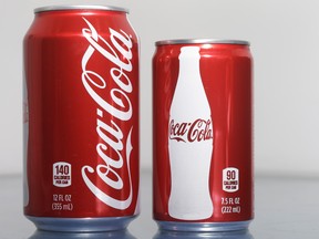 A 7.5-ounce can of Coca-cola, right, is posed next to a 12-ounce can for comparison, Monday, Jan. 12, 2015 in Philadelphia. As people cut back on soda, the two beverage giants, Coke and Pepsi, are increasingly pushing smaller cans and bottles they say contain fewer calories and induce less guilt. (AP Photo/Matt Rourke)