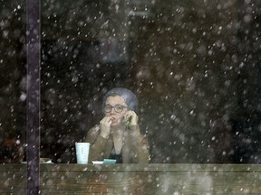 A woman watches the snow fall from the safety of the downtown Starbucks as snow blankets Windsor on Wednesday, January 21, 2015.       (TYLER BROWNBRIDGE/The Windsor Star)