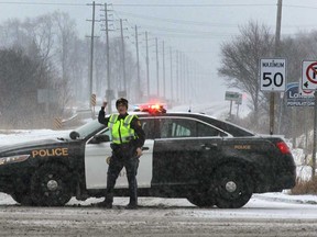 An Ontario Provincial Police officer blocks the eastbound lane of county Rd. 42 at Manning Rd. on Wed. Jan. 21, 2015, due to a multi-vehicle accident. Local police were busy with numerous accident due to a early morning snowfall. (DAN JANISSE/The Windsor Star)