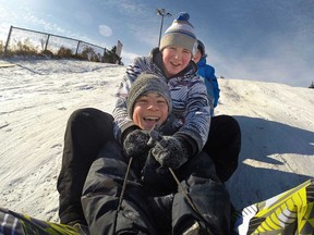From front, Evan Facecchia, 12, and brothers, Calvin McIntyre, 14, and Heath McIntyre, 12, are all smiles as they slide down the hill at Malden Park Saturday, Jan. 10, 2014.  (DAX MELMER/The Windsor Star)