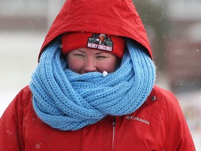 Stacy Harford tries to keep warm with a scarf, tuque, and hooded jacket while on an afternoon walk as temperatures in the region plummeted to start the work week, Monday, Jan. 5, 2015.  (DAX MELMER/The Windsor Star)
