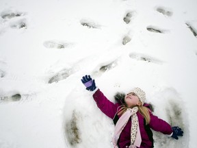 In this file photo, kindergartner Paige Chisholm, 6, reaches as far as she can as her cap falls over her face while making a snow angel on Thursday, Feb. 28, 2013 during recess at Cook Elementary School in Grand Blanc, Mich. (AP Photo/The Grand Rapids Press, Jake May)