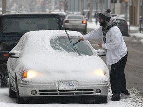 Matt Stamatovski brushes snow off his car in downtown Windsor, ON. on Monday, Jan. 12, 2015. (DAN JANISSE/The Windsor Star)