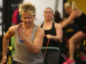 Helen Piatkowski, left, takes part in the World's Largest Simultaneous Group Workout at Bryan's Fitness Inferno, Saturday, Jan. 3, 2014.  (DAX MELMER/The Windsor Star)