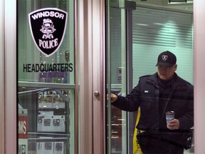 A Windsor police officer at the doors of the downtown headquarters on the night of Dec. 3, 2014. (Nick Brancaccio / The Windsor Star)