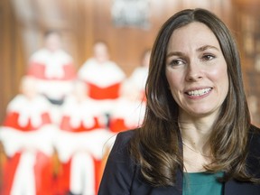 Grace Pastine, litigation director of the BC Civil Liberties Association, is photograph in front of a portrait of the Supreme Court Justices in the lobby of the Supreme Court of Canada after it struck down the ban on doctor-assisted suicide Friday February 06, 2015. (Darren Brown/Ottawa Citizen)