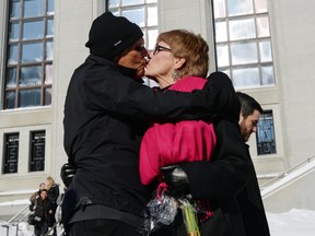 Lee Carter, right, and her husband Hollis Johnson kiss outside The Supreme Court of Canada, Friday morning, Feb. 6, 2015, in Ottawa, Ontario. Canada's highest court Friday, unanimously struck down a ban on doctor-assisted suicide for mentally competent patients with terminal illnesses. Carter and her husband accompanied her 89-year-old mother Kathleen (Kay) Carter, who suffered from spinal stenosis, to Switzerland in 2010 where assisted suicide is legal, to end her life. (AP Photo/The Canadian Press, Sean Kilpatrick)